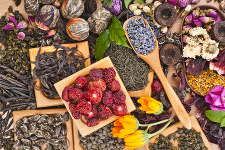 Collection of different dry types tea  green,black, herbal  in wooden spoon on kitchen table background, top viewの写真素材