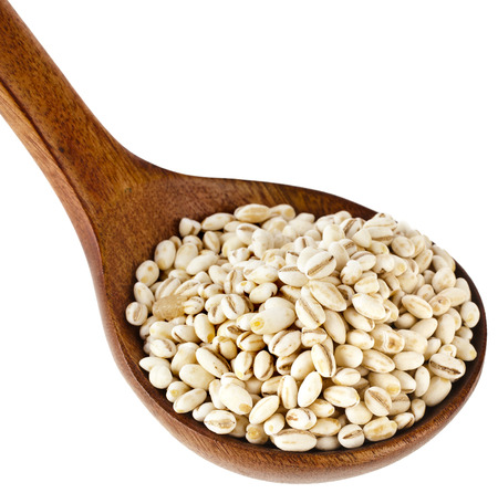 pearl barley in a wooden spoon isolated on white backgroundの写真素材