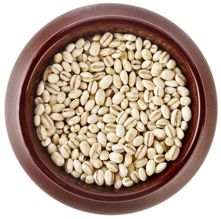 pearl barley porridge in a clay pot surface top view isolated on white backgroundの写真素材