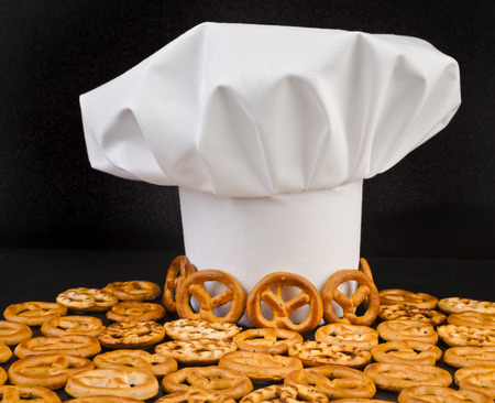 Chef Hat and pretzels isolated on black table backgroundの写真素材