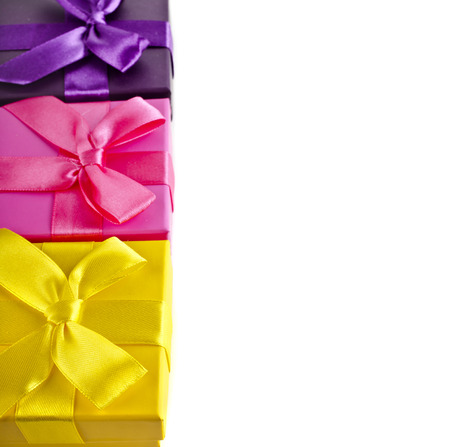Border row of colorful gift boxes wrapped ribbon bows surface close up isolated on white backgroundの写真素材