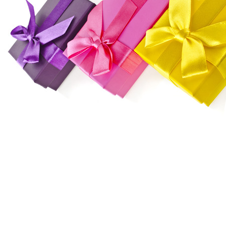 colorful gift boxes wrapped ribbon bows surface close up isolated on white backgroundの写真素材