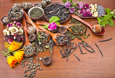 assortment variety tea in wooden spoon on kitchen wooden table backgroundの写真素材