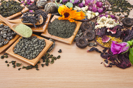 Collection of different dry types tea  green,black, herbal  in spoon on kitchen wooden table background, top viewの写真素材
