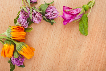 herbal flower heap on wooden surface top view with copy space backgroundの写真素材