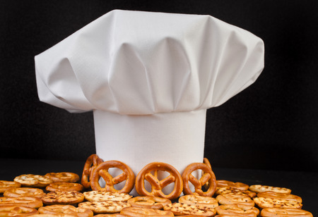 Chef Hat and pretzels isolated on black table backgroundの写真素材