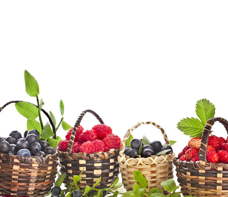 fresh forest berries   blueberries , raspberries and strawberries in the basket isolated on white backgroundの写真素材