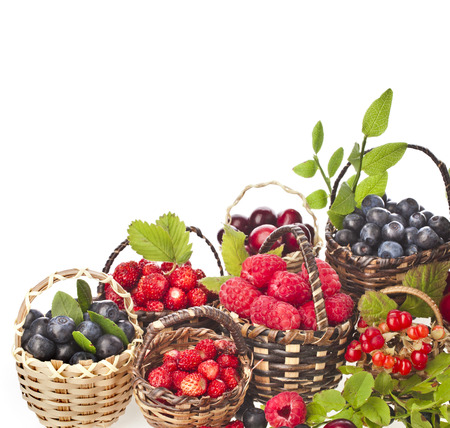 ripe wild berries mix in the basket isolated on white backgroundの写真素材