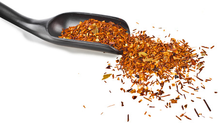 herbal tea loose rooibos leaves in wooden spoon isolated on white backgroundの写真素材