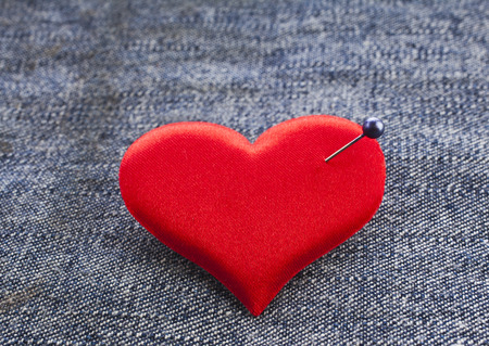 Valentine's day fabric sack texture background, red heart symbol with needleの写真素材