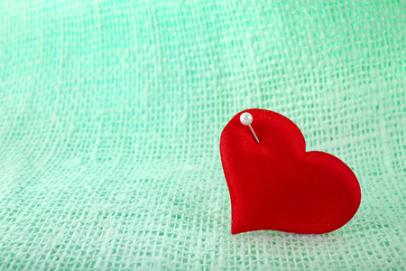 Valentine's day fabric sack texture background, red heart symbol with needleの写真素材