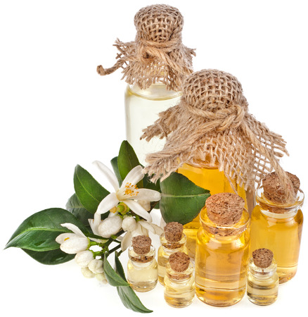 Glass bottles of herbal essences oil with fresh citrus flowers isolated on white backgroundの写真素材