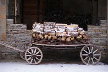 Old cart with wood with stone wall at backgroundの写真素材
