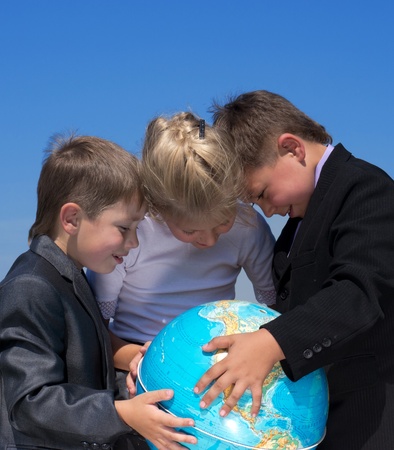 three friends holding earth globe in hands, outdoor shotの写真素材
