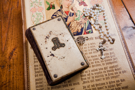 historic bible, rosary and old image of saint on wooden flooring,の写真素材