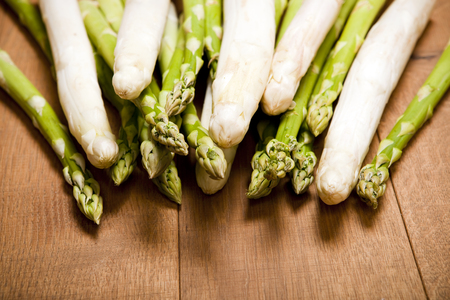mix of green and white asparagus on rustic wooden backgroundの写真素材