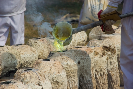 Illustration of molten metal being poured from a foundry crucible statue