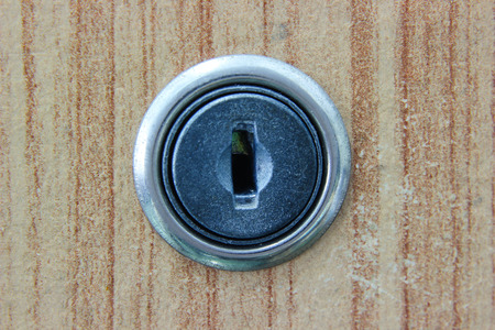 close up keyhole door lock on wood