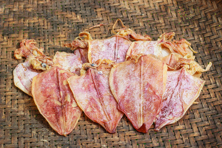 Dried squids on Bamboo threshing basketの写真素材