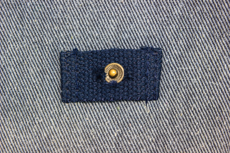 close up metal button on jeans texture