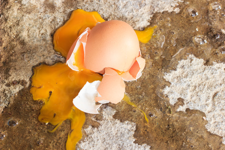 broken egg on dirty ground