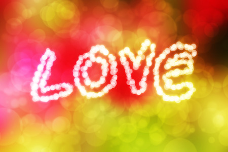 inscription love with defocused lights on abstract colorful bokeh backgroundの写真素材