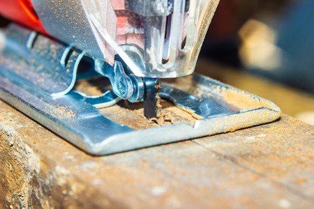Close-up sawing electric jigsaw in the boardの写真素材