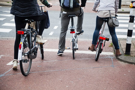 bicycle riders waiting at the traffic lightsの写真素材