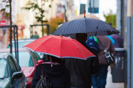 people with umbrellas in the rainy cityの写真素材