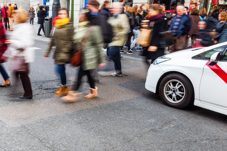 crowd of people in motion blur crossing a city streetの写真素材