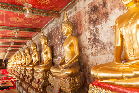 Buddha statues in a row inside the temple hall of Wat Suthat