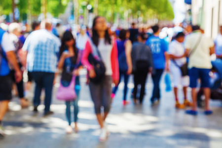 out of focus picture of a crowd of people walking in the cityの写真素材