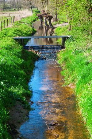 picturesque brook landscape between agricultural fields in The Netherlandsの写真素材