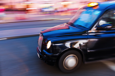 London, UK - June 19, 2016: London taxi in motion blur at night. The black London Taxis are one of the world famous symbols of London.のeditorial素材