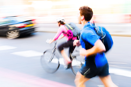 jogger and cyclist in city traffic with motion blurの写真素材