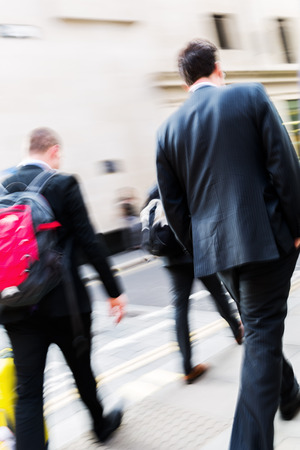 businessmen walking on the street in motion blurの写真素材