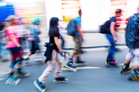 rollerblading people on a city street in motion blurの写真素材