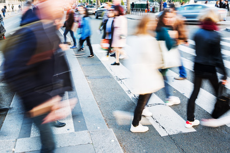 picture with motion blur of a crowd of people crossing a city street at the pedestrian crossingの写真素材