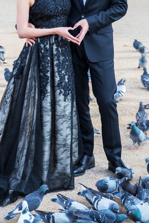 close up of a bridal couple making a heart with their handsの写真素材