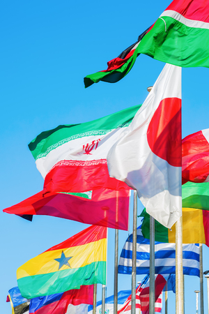 blowing flags of the world behind each other