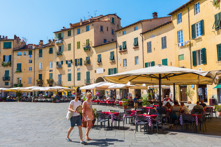 Lucca, Italy, - July 01, 2016: Piazza del Anfiteatro with unidentified people. The ring of buildings surrounding the square, follows the shape of the former 2nd century Roman Amphitheater of Luccaのeditorial素材