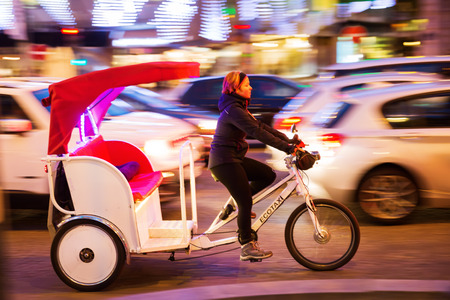 Paris, France - October 19, 2016: cycle rickshaw in motion blur on the Champs Elysees with unidentified woman. Cycle rickshaws are widely used in major cities worldwide, hired by passengers.のeditorial素材