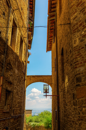 picturesque archway in the UNESCO listed old town of San Gimignano, Tuscany, Italyの写真素材