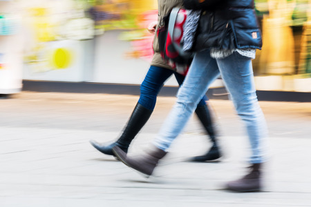 people walking on a shopping street with camera made motion blurの写真素材