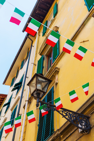 house facade with an antique street lamp and Italian flags in Florenceの写真素材