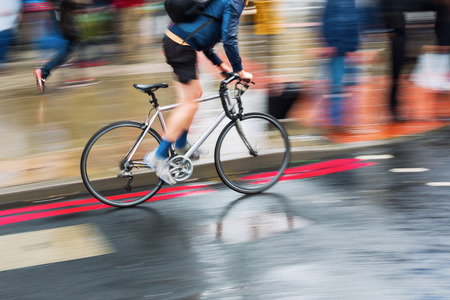 bicycle rider on a wet street in motion blur