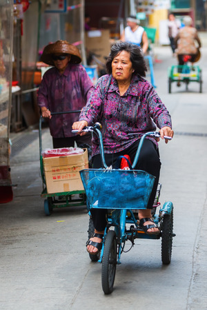 Tai O, Hong Kong - March 13, 2017: native unidentified woman with bicycle in Tai O. Tai O is a popular traditional fishing village on Lantau Island with unique stilt housesのeditorial素材