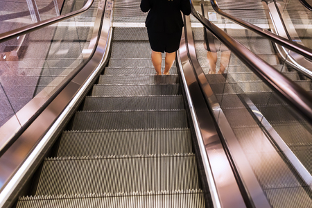 picture of an escalator with legs of a womanの写真素材