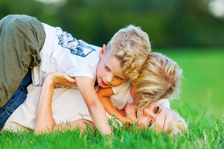 picture of a woman who romps with her two sons on the grassの写真素材
