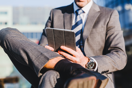 businessman makes a rest in the city and works with a tabletの写真素材